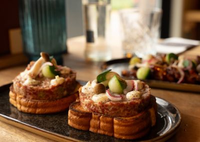 Brioche broodjes belegd met tartaar, radijs en komkommer