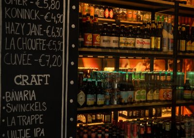 Krijtbord met bierprijzen naast de gevulde bierkoeling